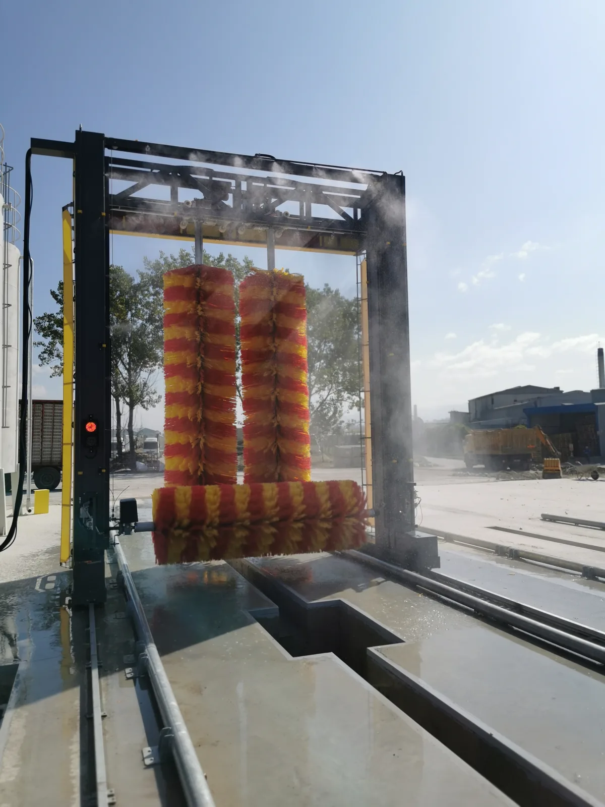 Wash gantry working inside a cloud of rinse spray